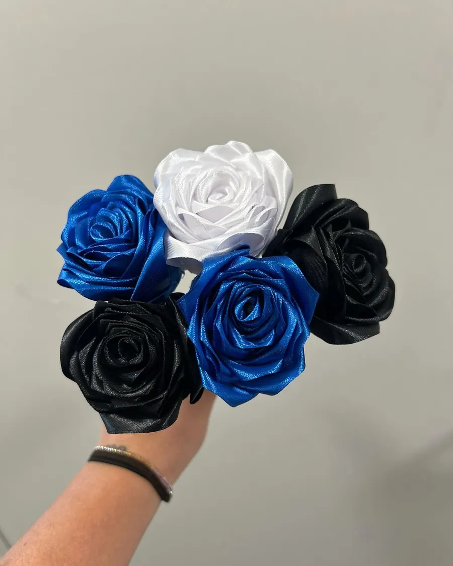 Roses en satin bleu roi, blanches et noires tenues à la main